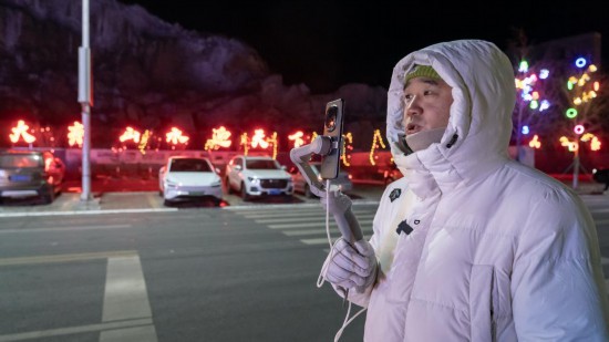 在吉林市阿什哈達(dá)霧凇觀景帶，霧凇播報員正在直播。新華社記者 李典 攝