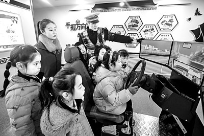 山東省榮成市公安局道路交通安全宣傳教育基地，交警帶領(lǐng)小學(xué)生現(xiàn)場(chǎng)體驗(yàn)?zāi)M駕駛。新華社發(fā)