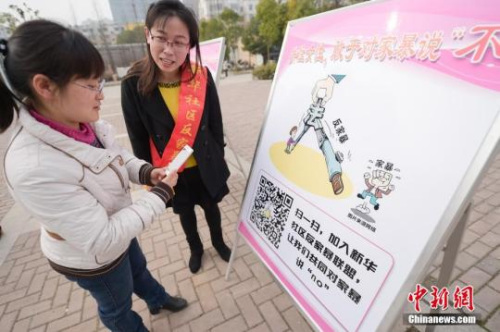 資料圖：今年3月8日，安徽合肥新華社區(qū)志愿者夏一瓊(右)向市民普及反家暴相關(guān)法律知識(shí)。鐘欣 攝